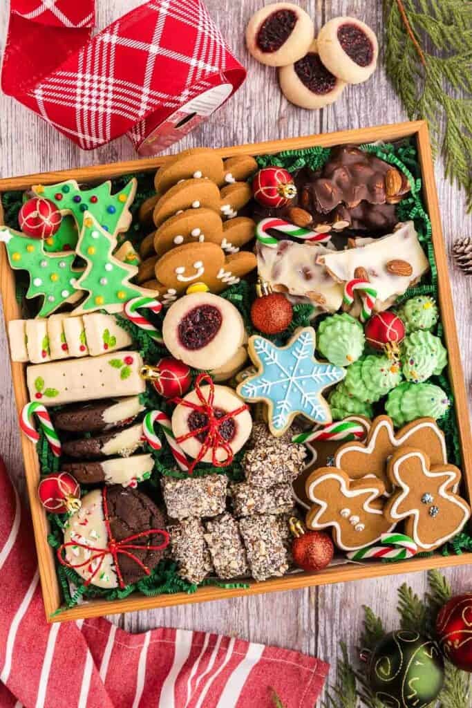 overhead shot of festive chocolate cookies with colorful icing and sprinkles on a wooden board, holiday themed
