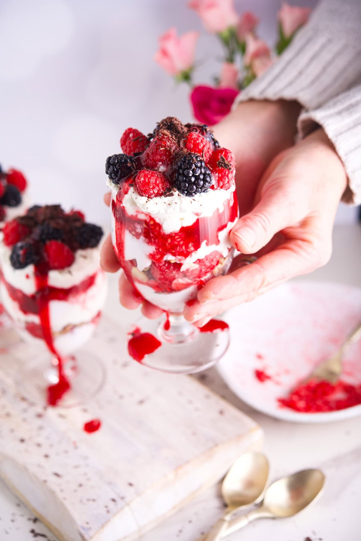layered raspberries and cream yogurt parfait in tall glass
