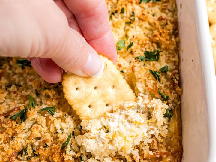 Creamy baked jalapeño popper dip in a rustic serving dish with crackers