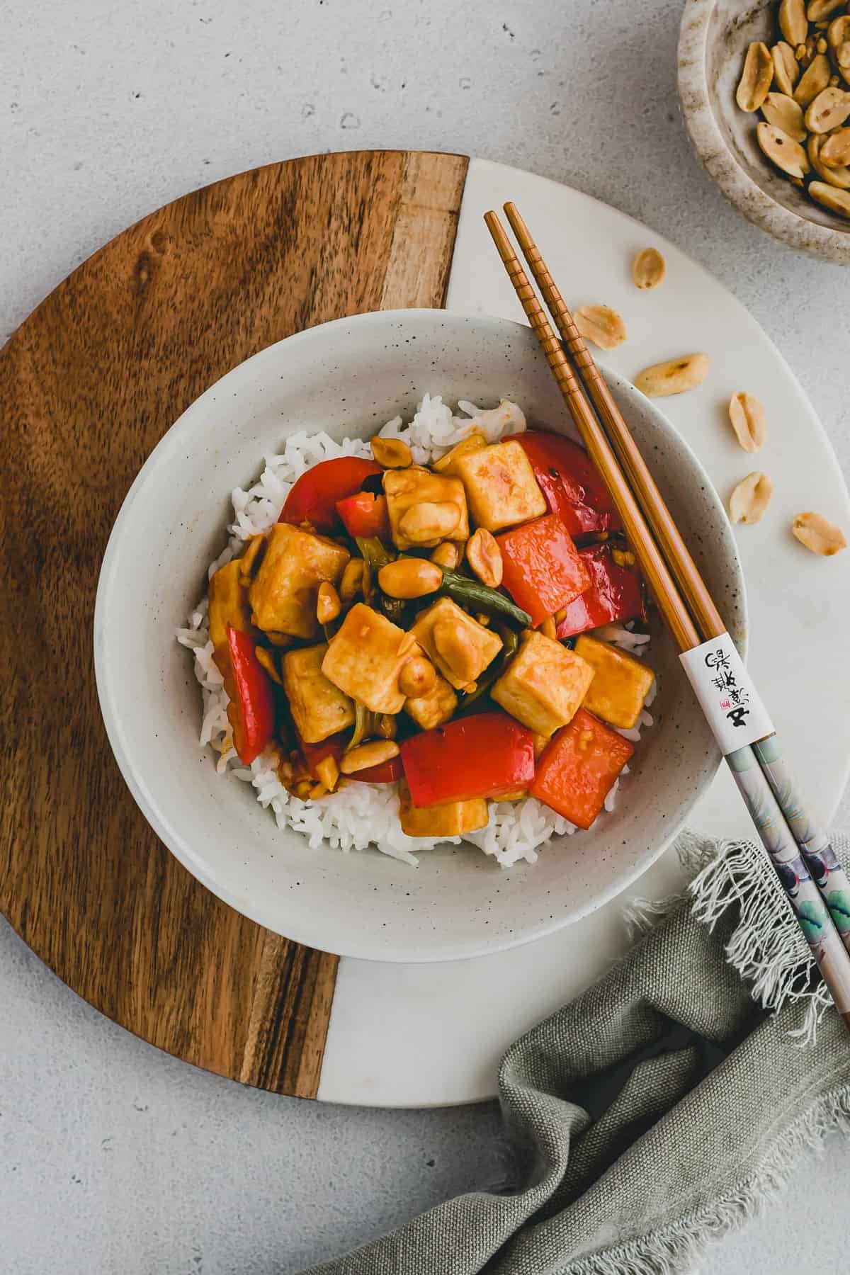 Kung Pao Tofu served in a bowl with chopsticks