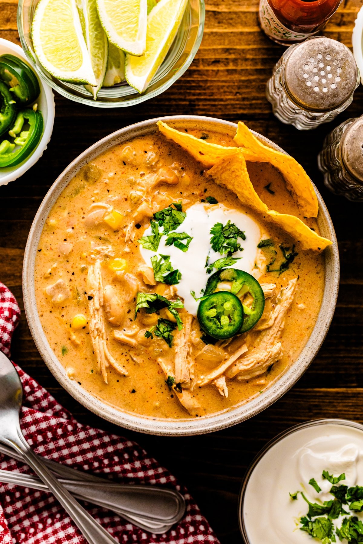 hearty bowl of creamy roasted garlic white chicken chili with toppings, cozy setting