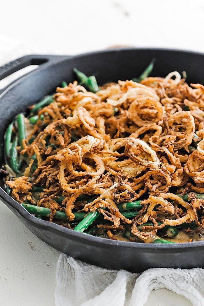 classic green bean casserole topped with golden fried onions, close-up, warm lighting