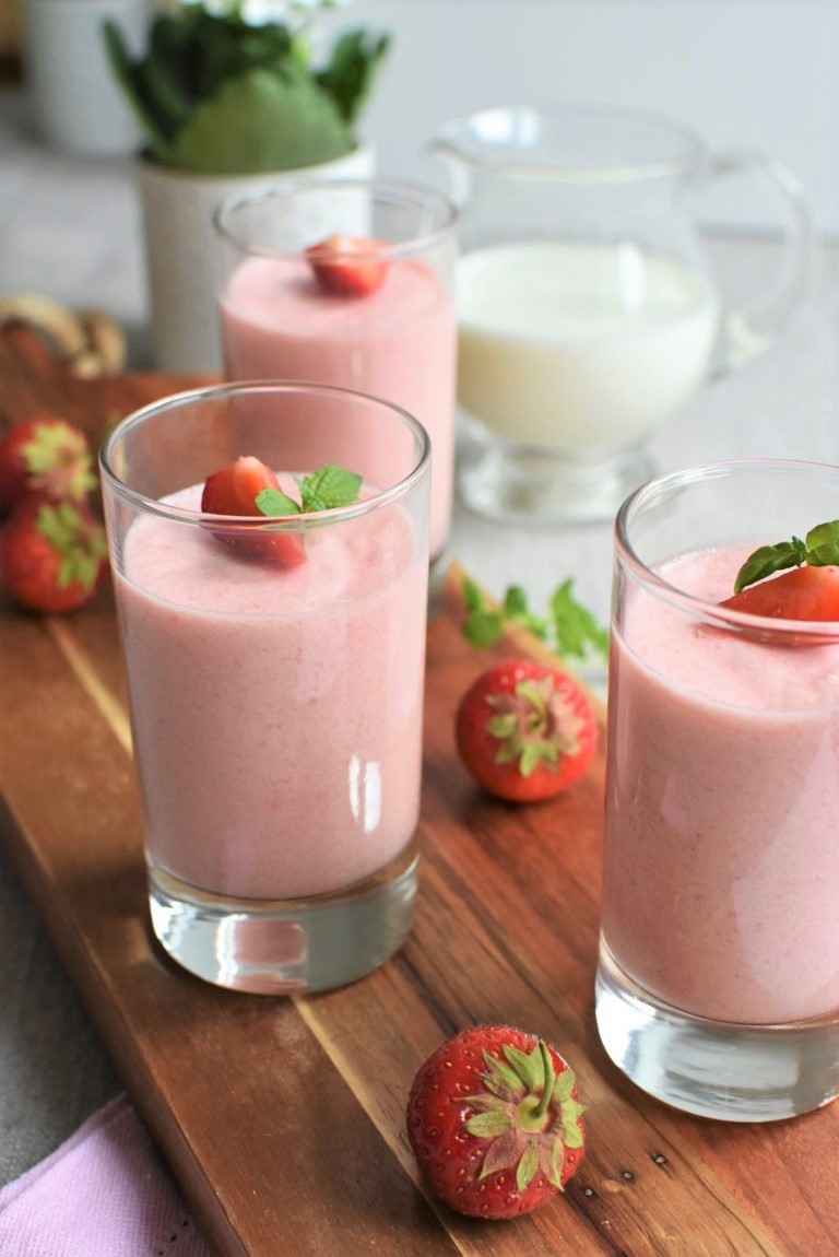a refreshing strawberry mousse ice cream float in a tall glass, garnished with fresh strawberries and mint