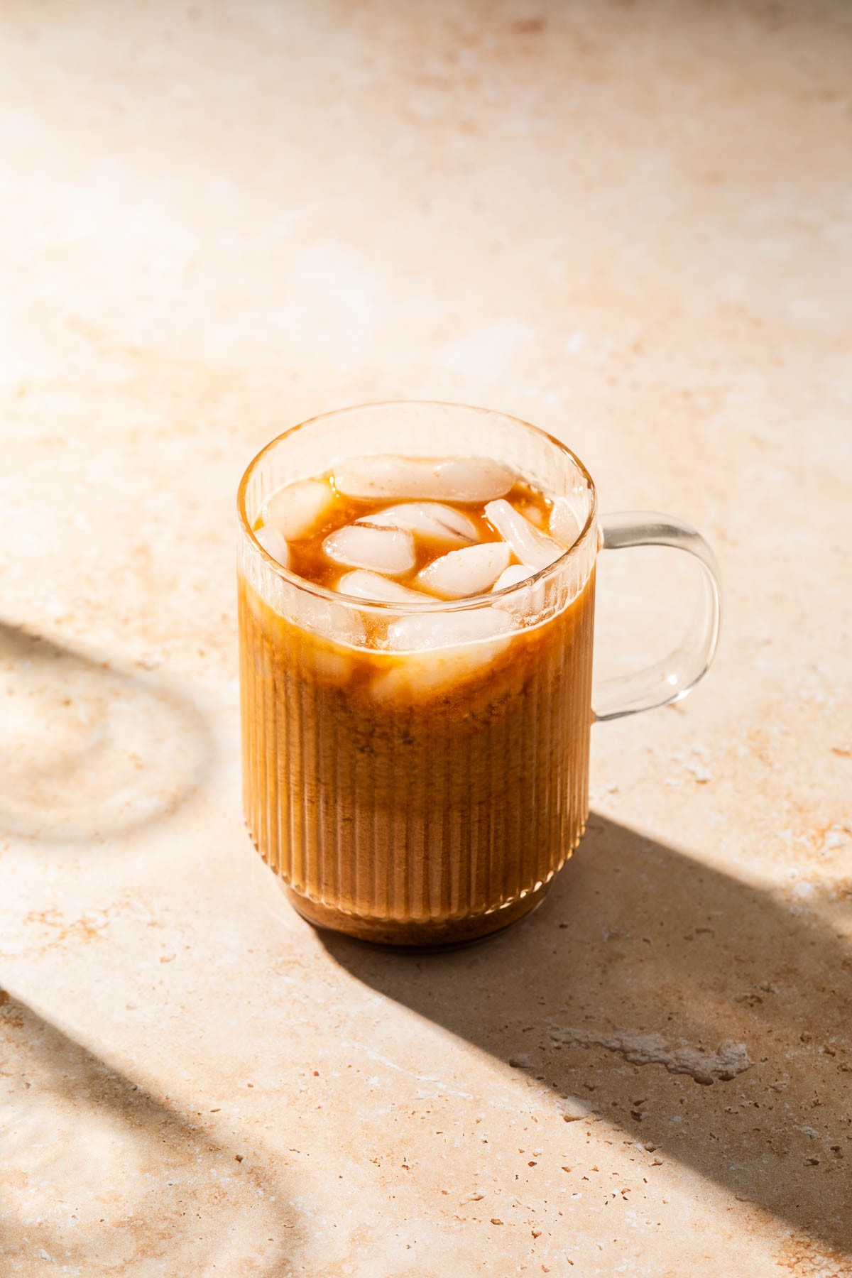 close-up of hemp milk cold brew in a glass with coffee beans and hemp seeds
