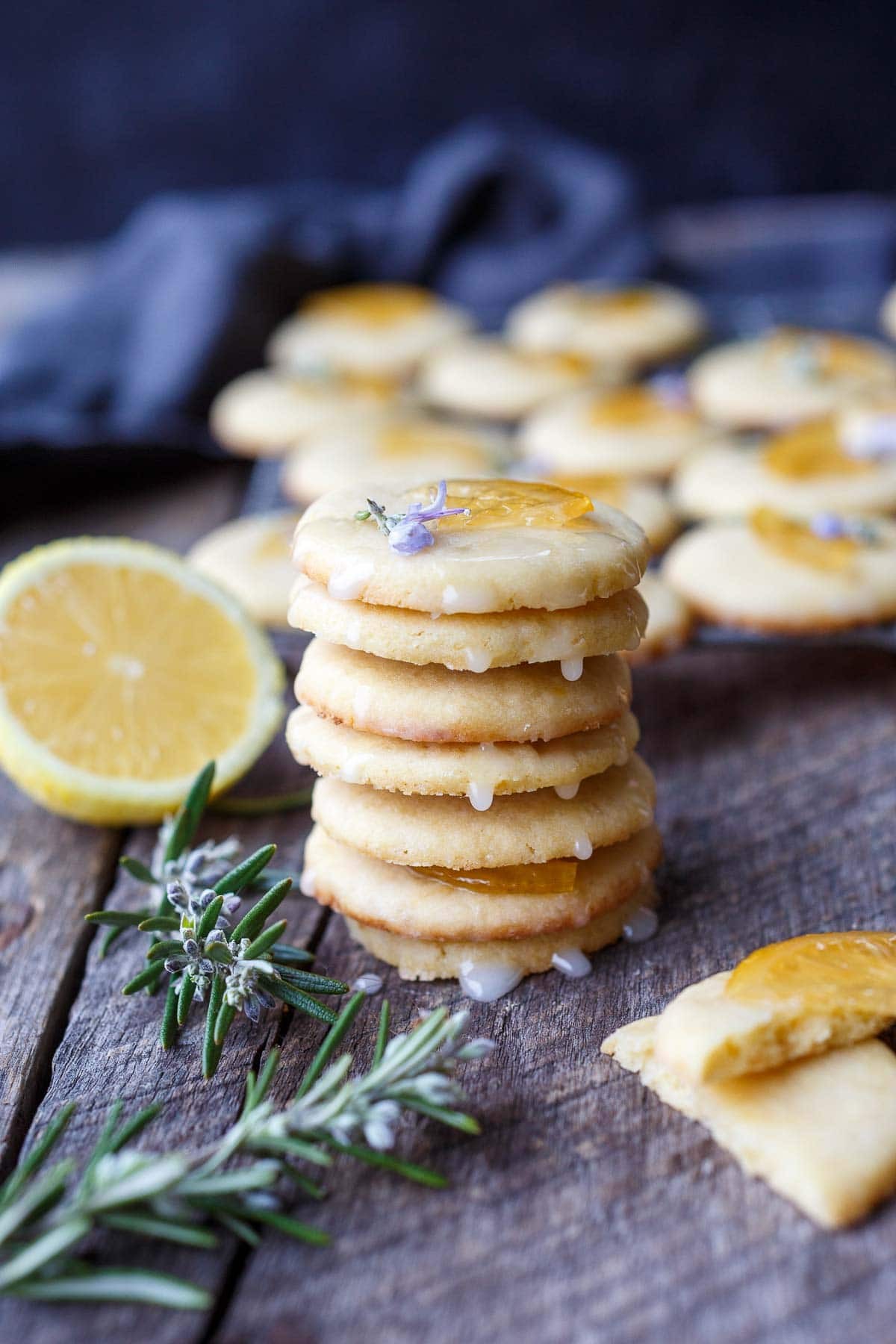 freshly baked sugar cookies with bright yellow lemon glaze and zest, on a rustic wooden board