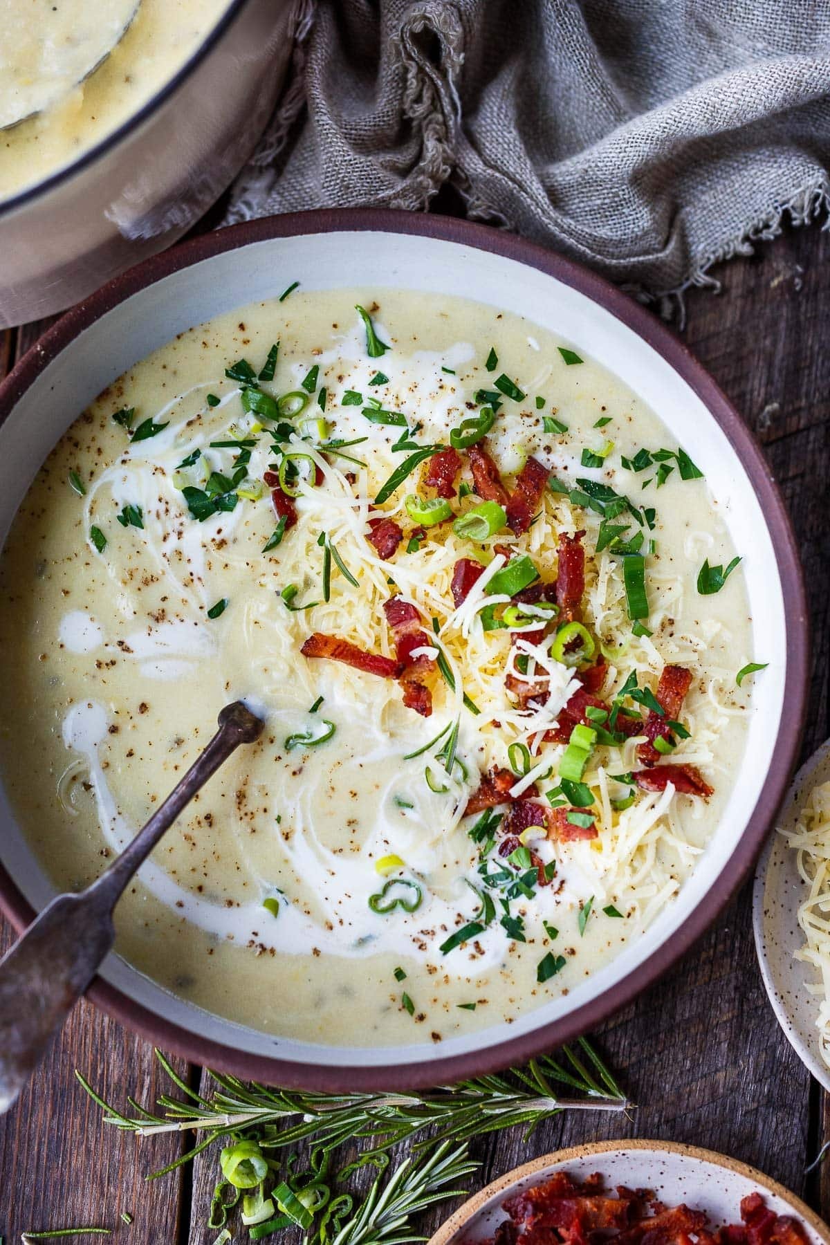 Creamy herb-loaded potato soup in a rustic bread bowl, garnished with fresh chives and a swirl of cream