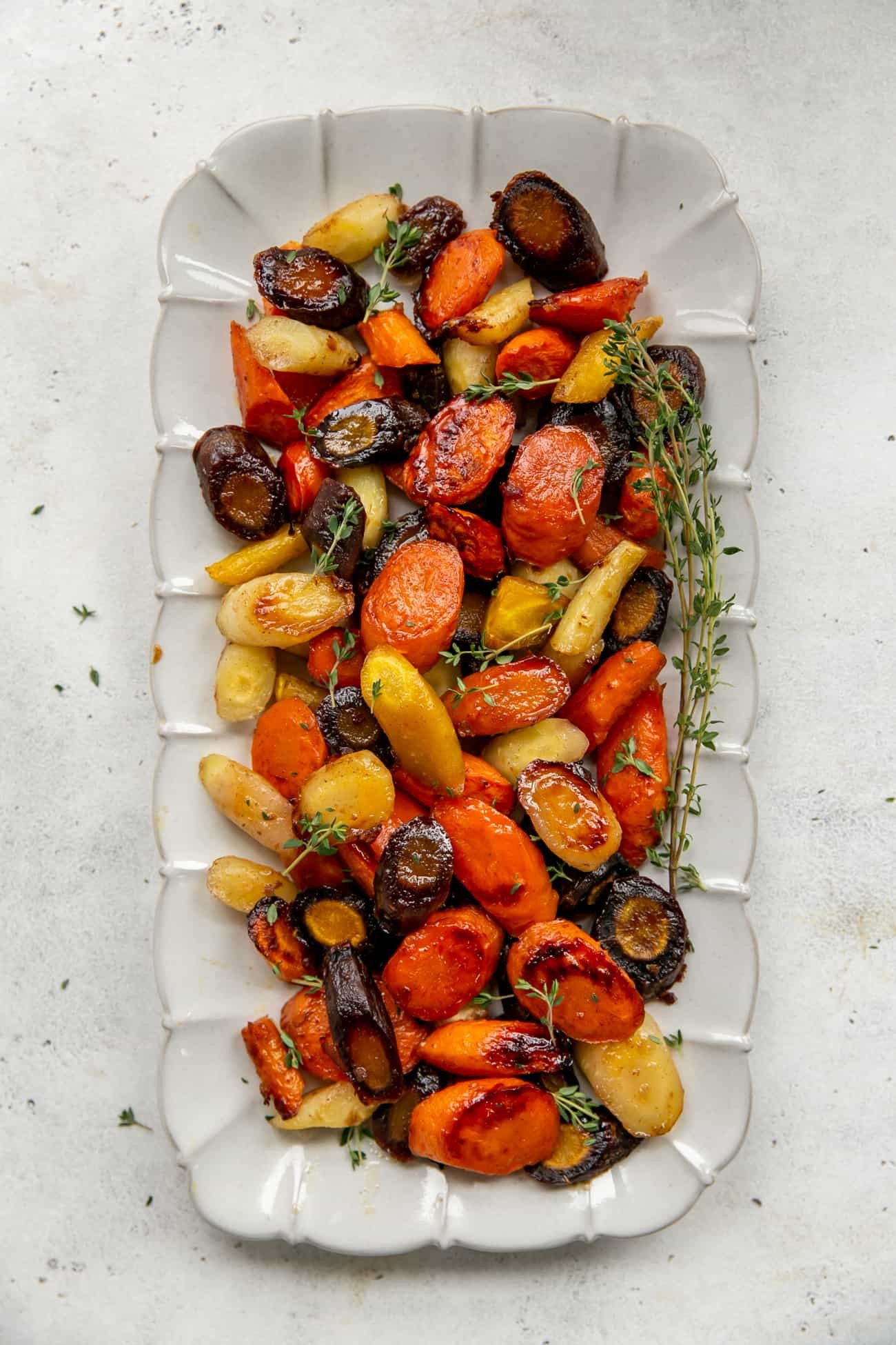 Platter of glistening honey glazed carrots with fresh herbs