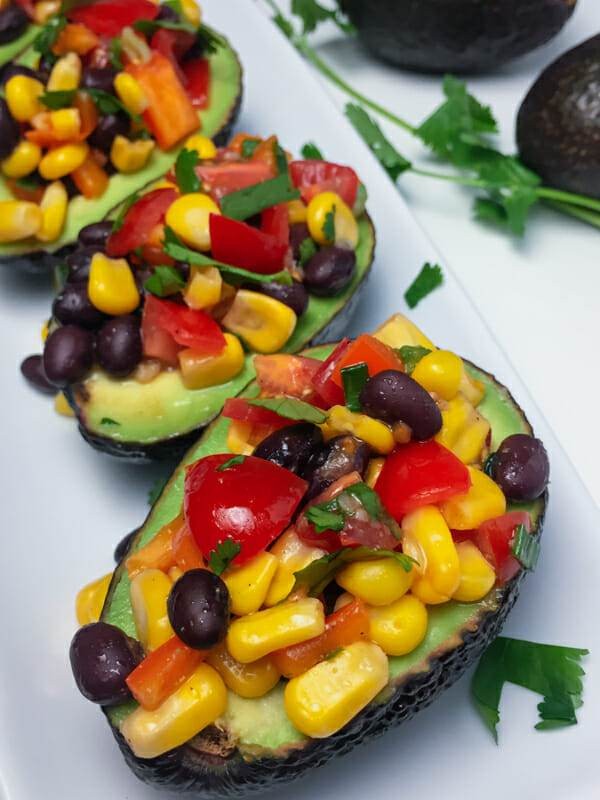 Black bean and corn stuffed avocados on a rustic wooden table