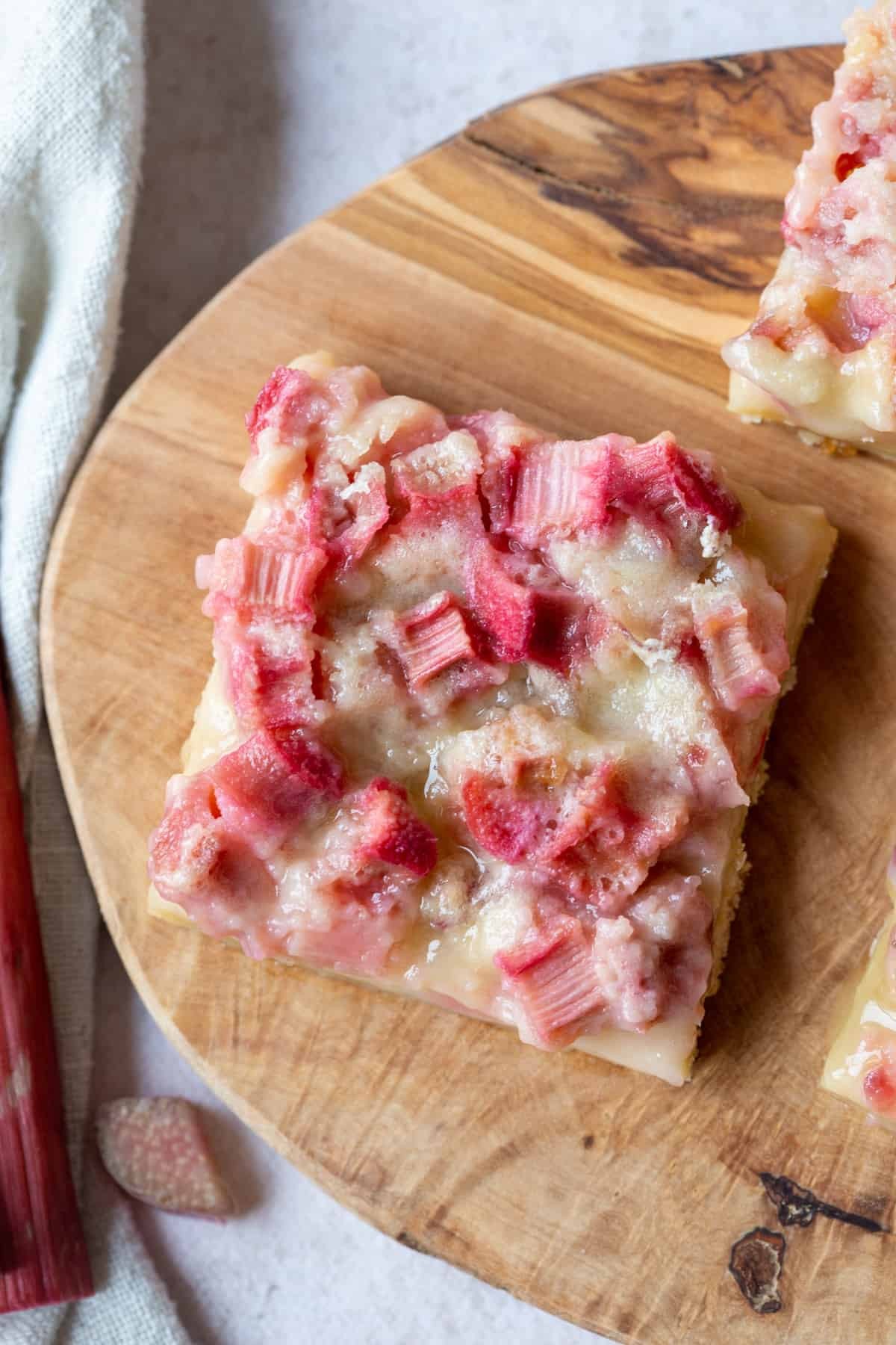 rhubarb polenta bars freshly baked on a wooden cutting board