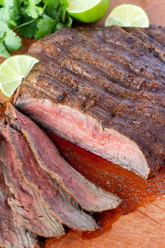 grilled chili lime flank steak on a wooden cutting board