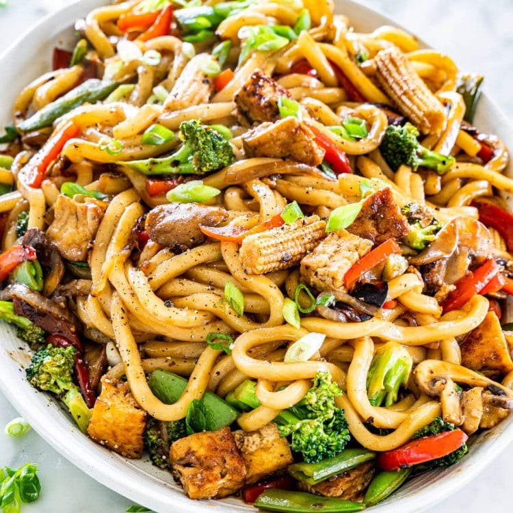 Tofu stir-fry with udon noodles in a wok