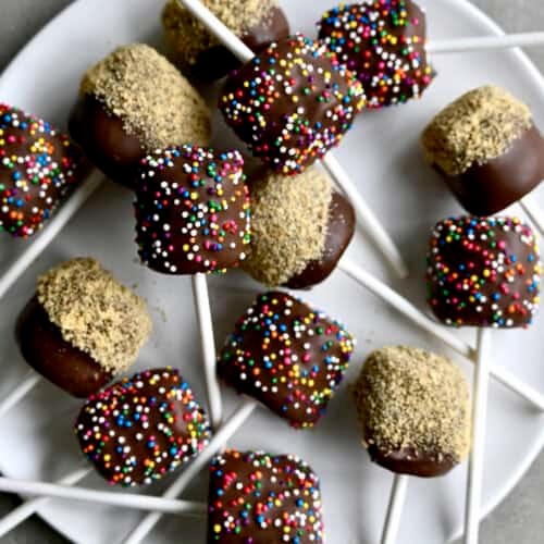 plate of chocolate-dipped marshmallows with festive sprinkles, close-up, soft lighting