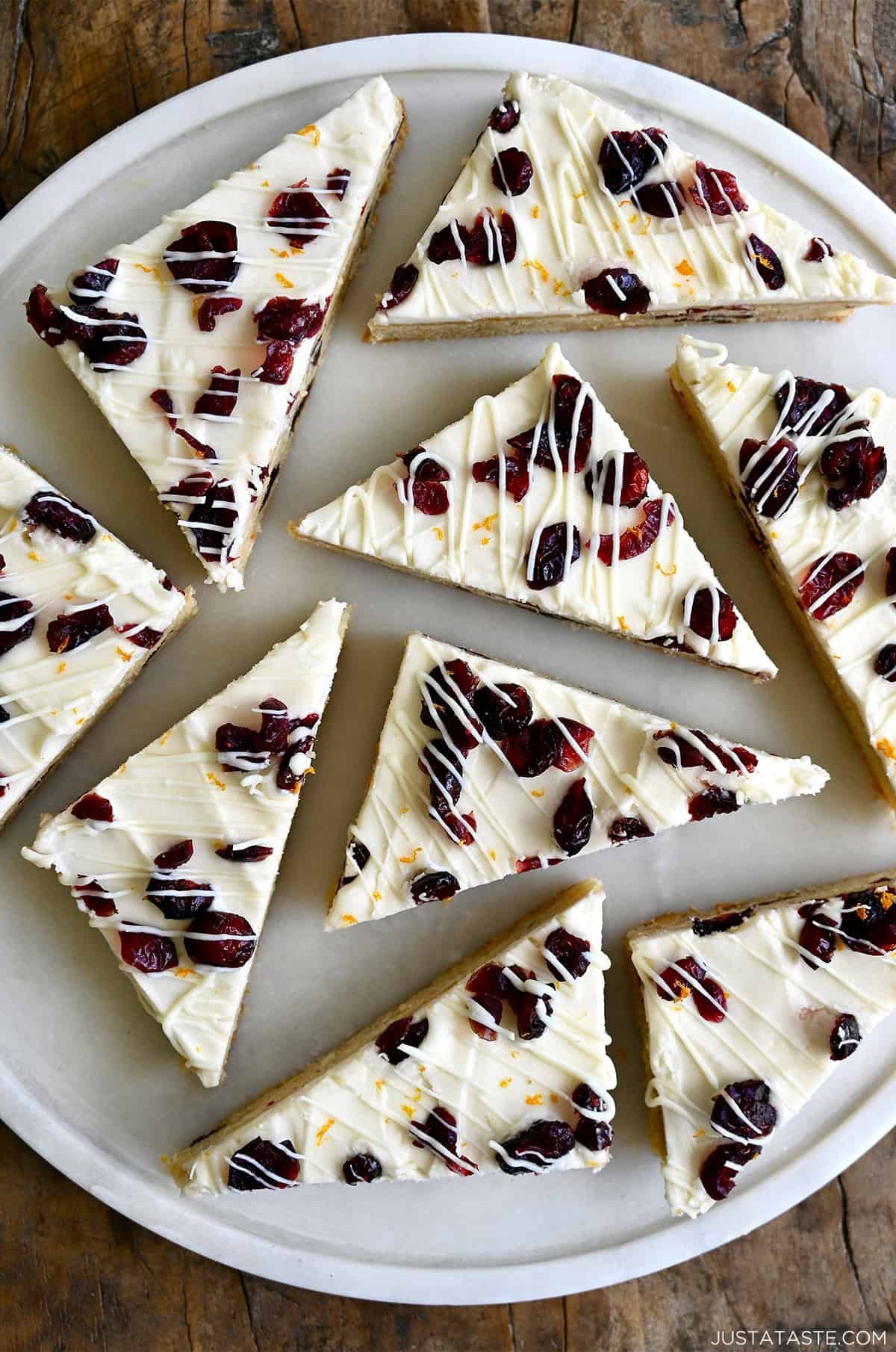 Festive cranberry bliss bars with white chocolate drizzle on a holiday platter