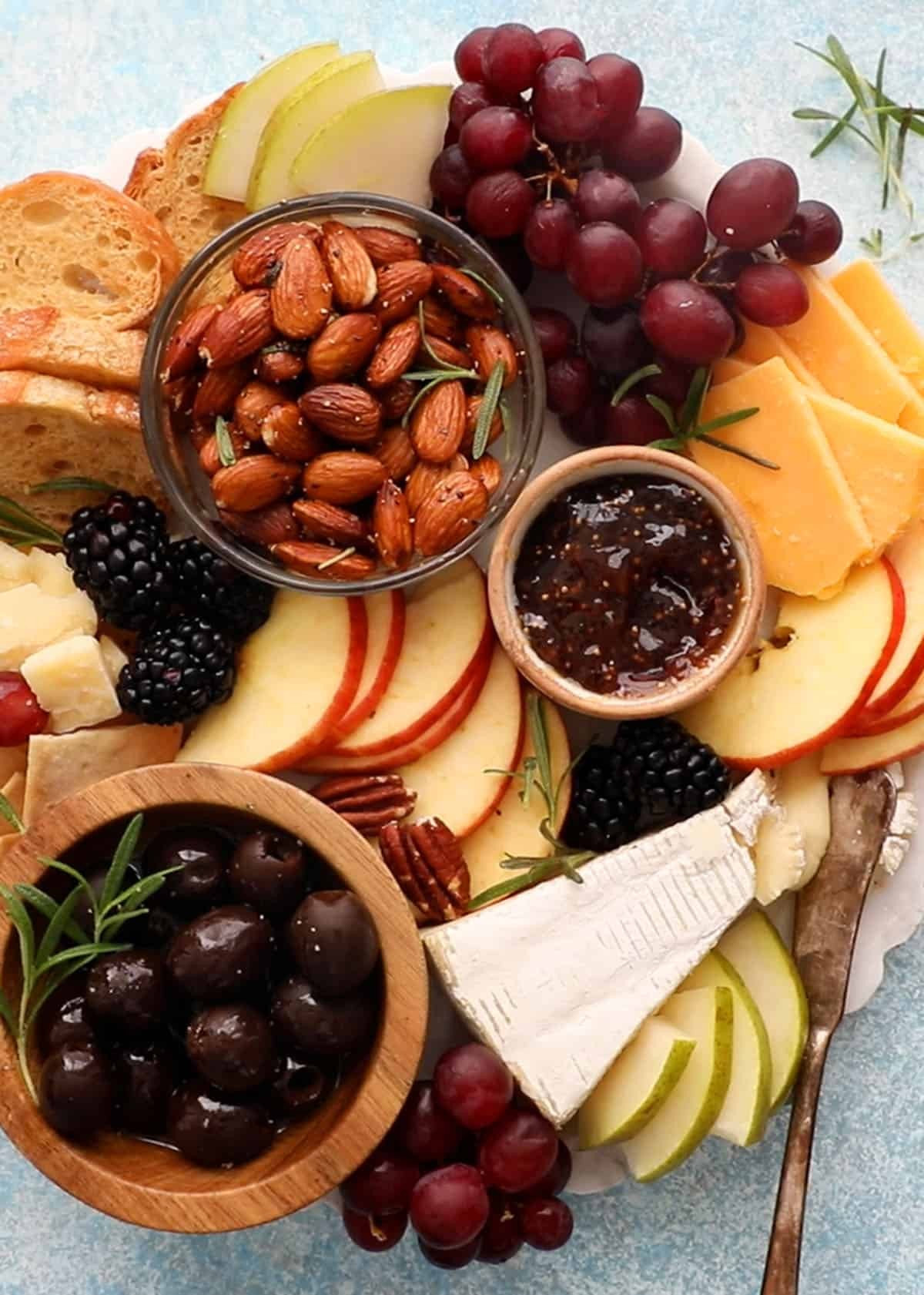 Arrangement of cheese, crackers, fruits, and nuts in a bento box