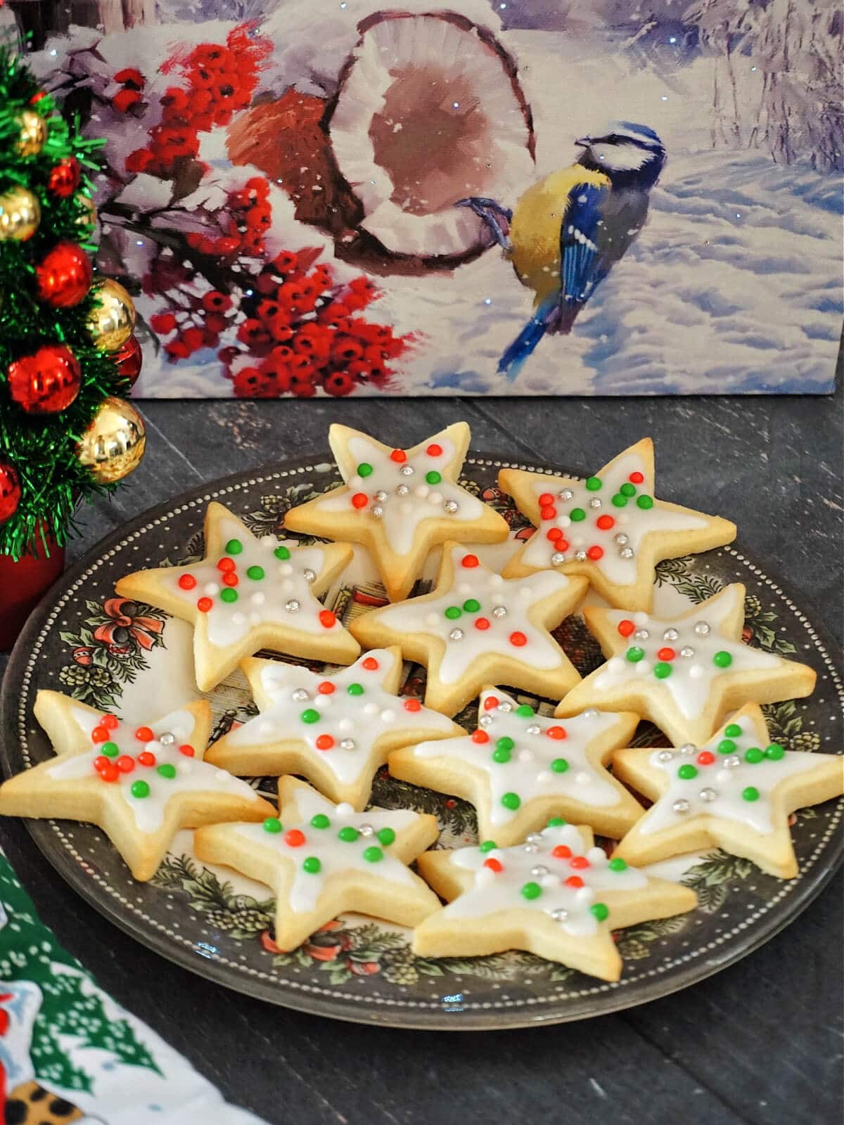 Children decorating star-shaped sugar cookies with colorful icing, joyful expressions, festive kitchen, close-up, natural light