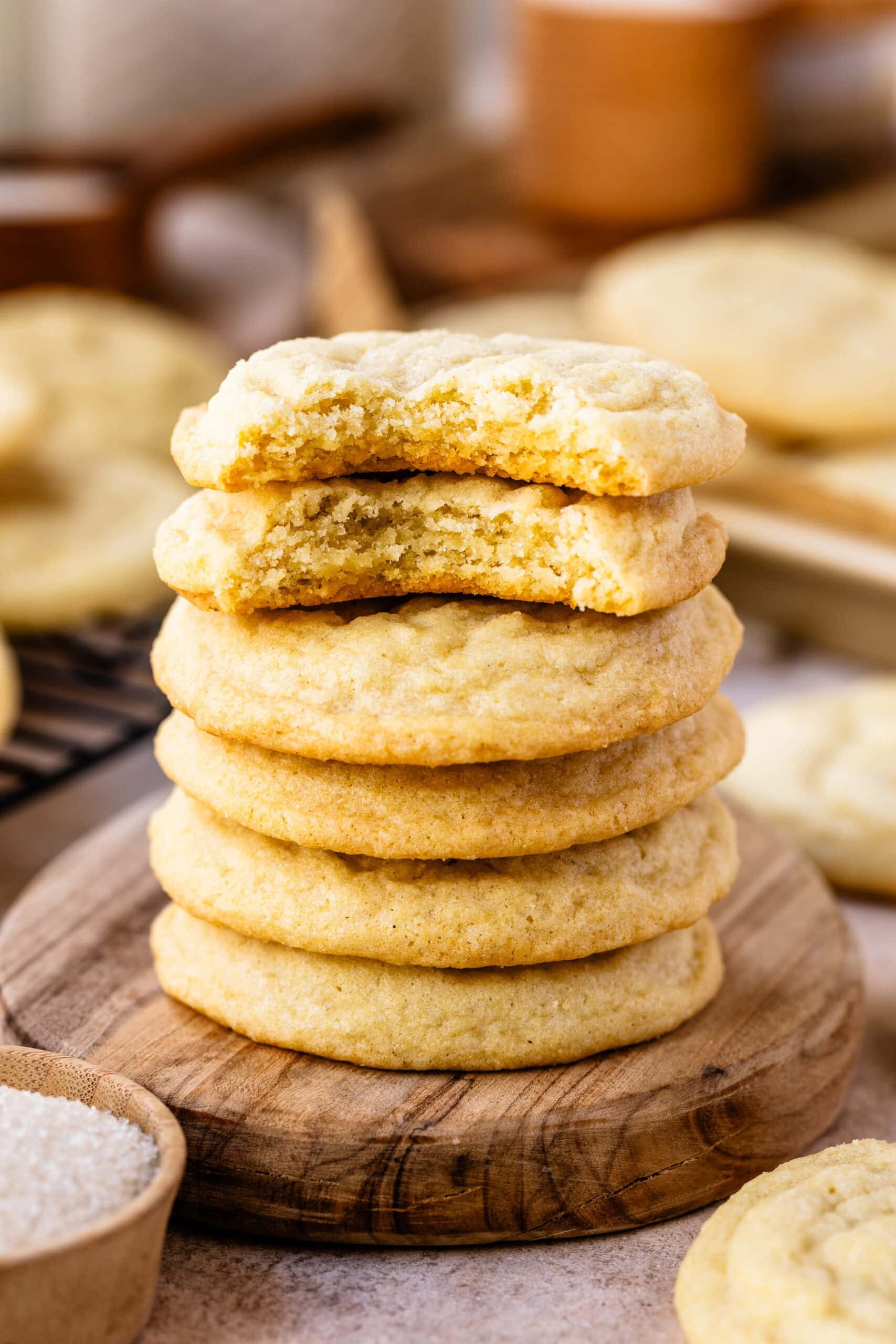 stack of perfectly baked sugar cookies with powdered sugar, warm lighting, cozy kitchen background