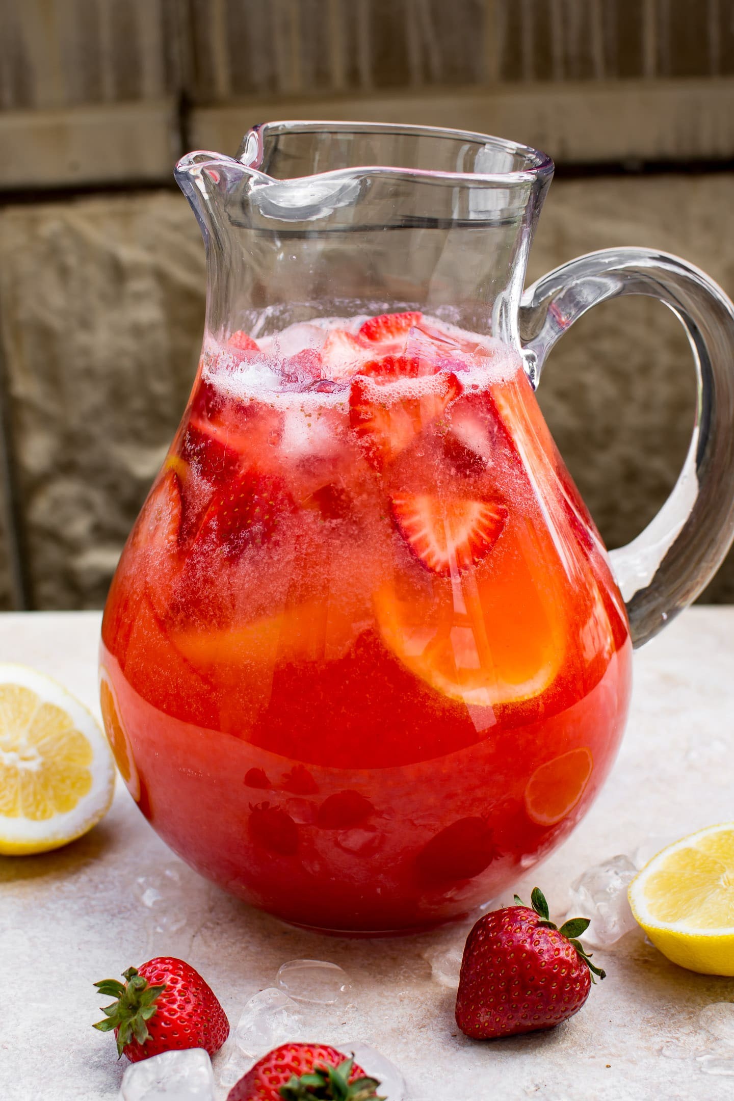 pitcher of homemade strawberry elderflower lemonade with lemon slices and strawberries
