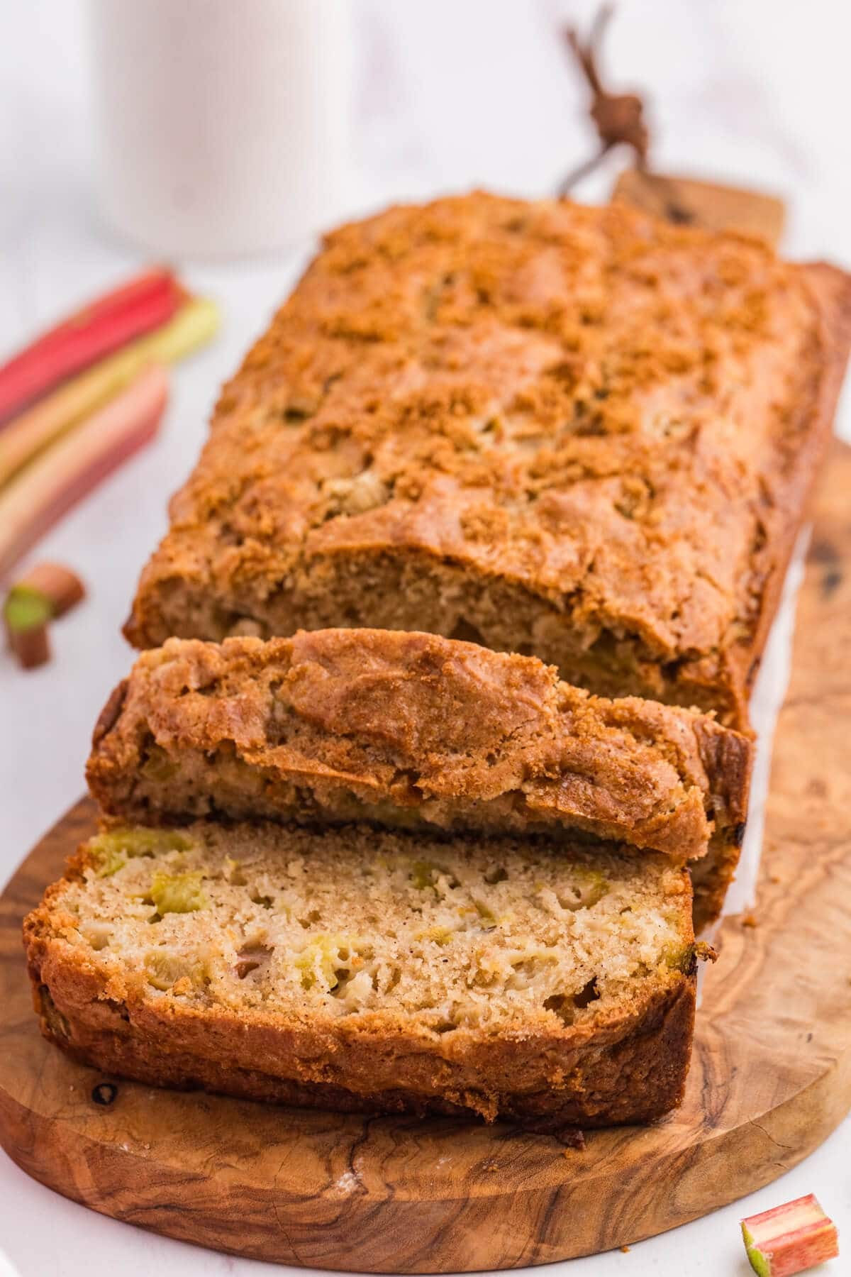 slice of pineapple rhubarb bread on a wooden cutting board