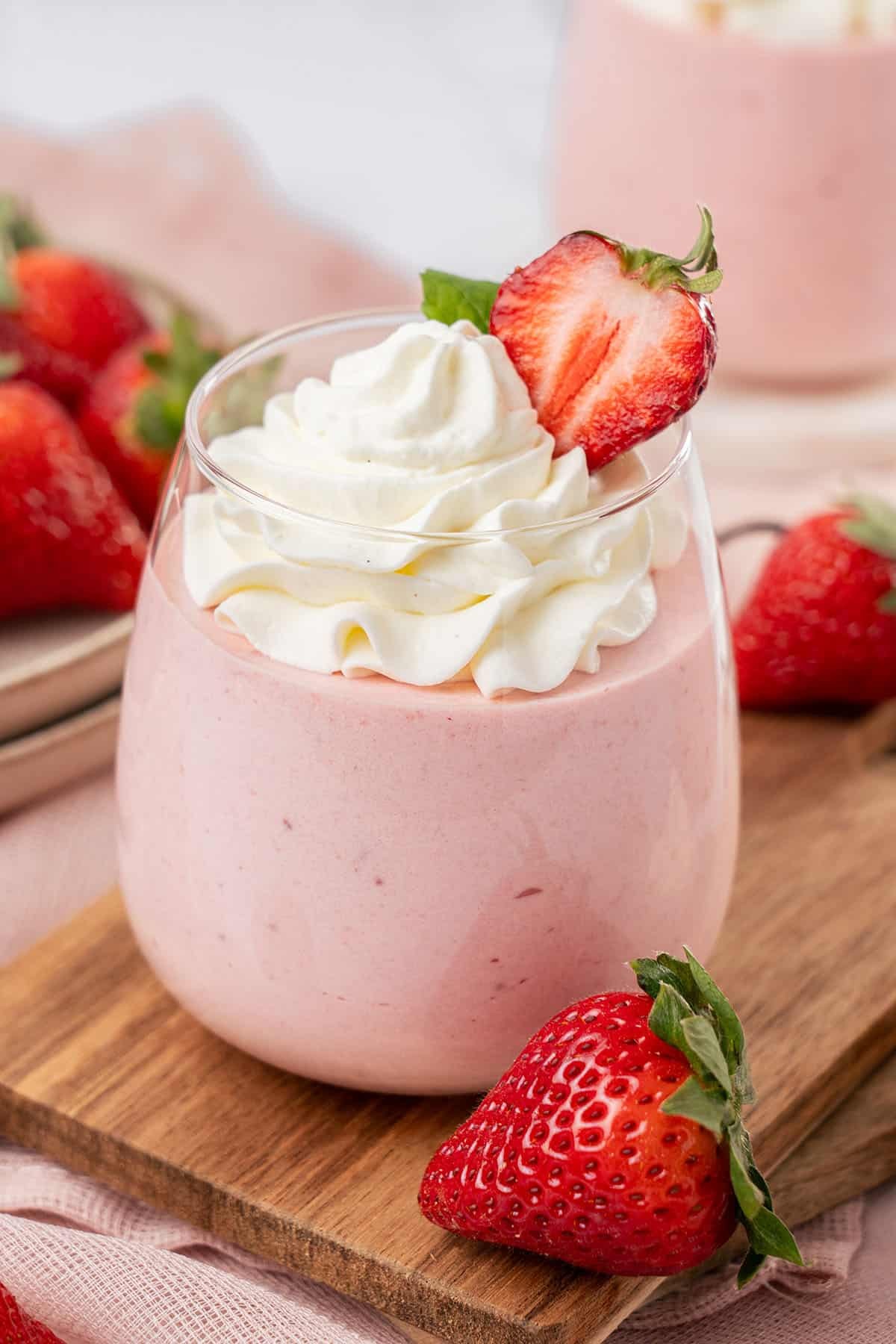 layered strawberry mousse in a glass with fresh strawberries and sparkling wine