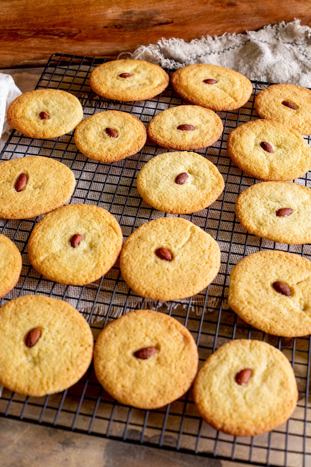 almond cookies with crisp edges close up, golden brown, on a cooling rack