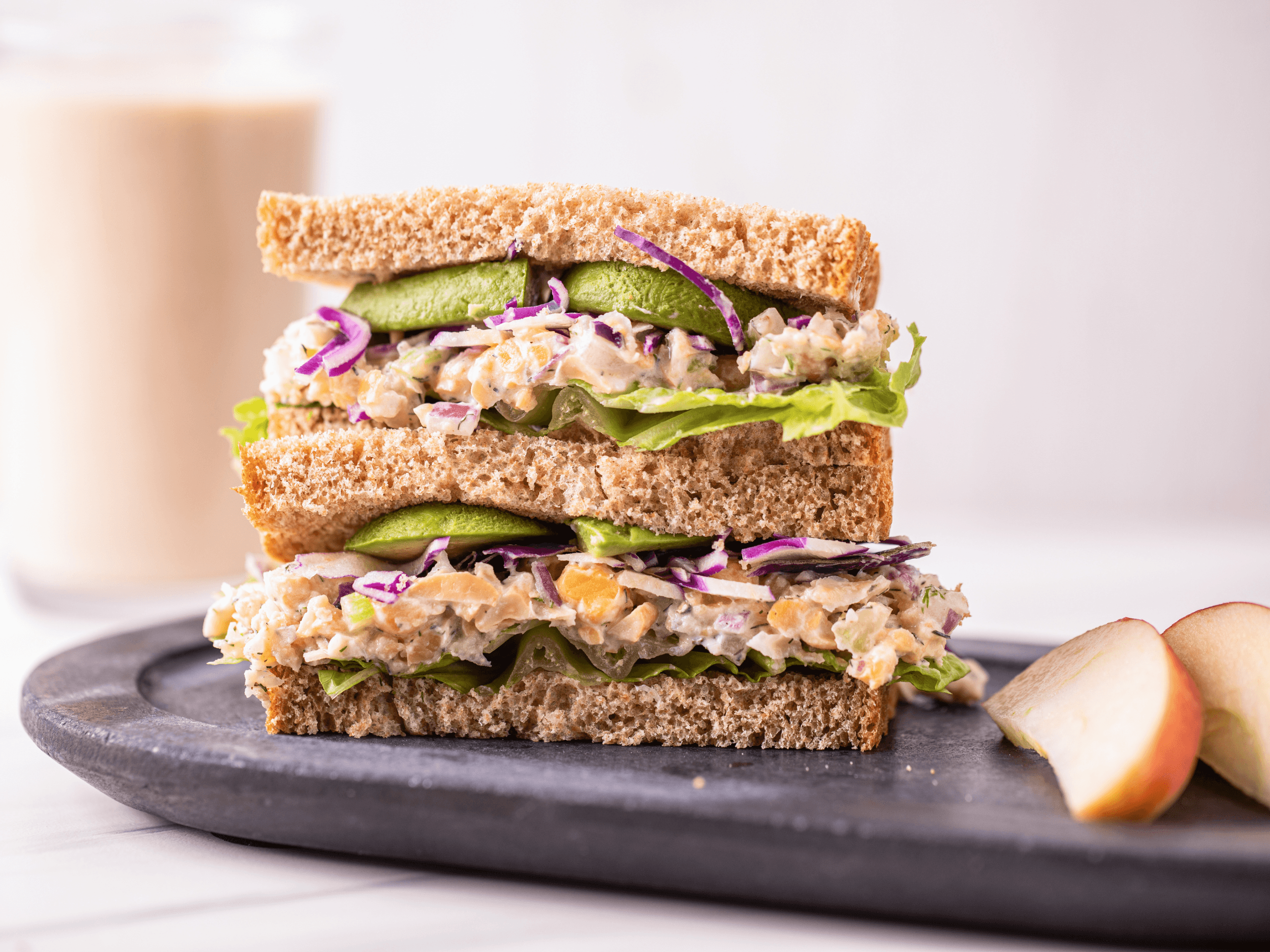 chickpea salad sandwich with dill and celery on a wooden board