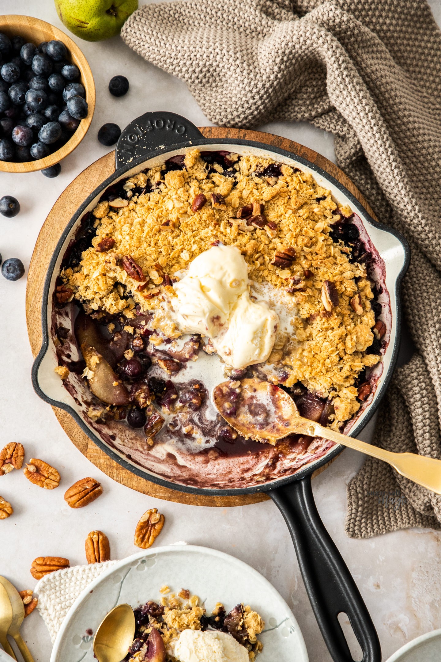 pear and blueberry crisp with lemon zest, golden brown topping