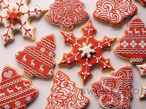 Elegant Christmas sugar cookies with glossy white and red icing in a festive setting