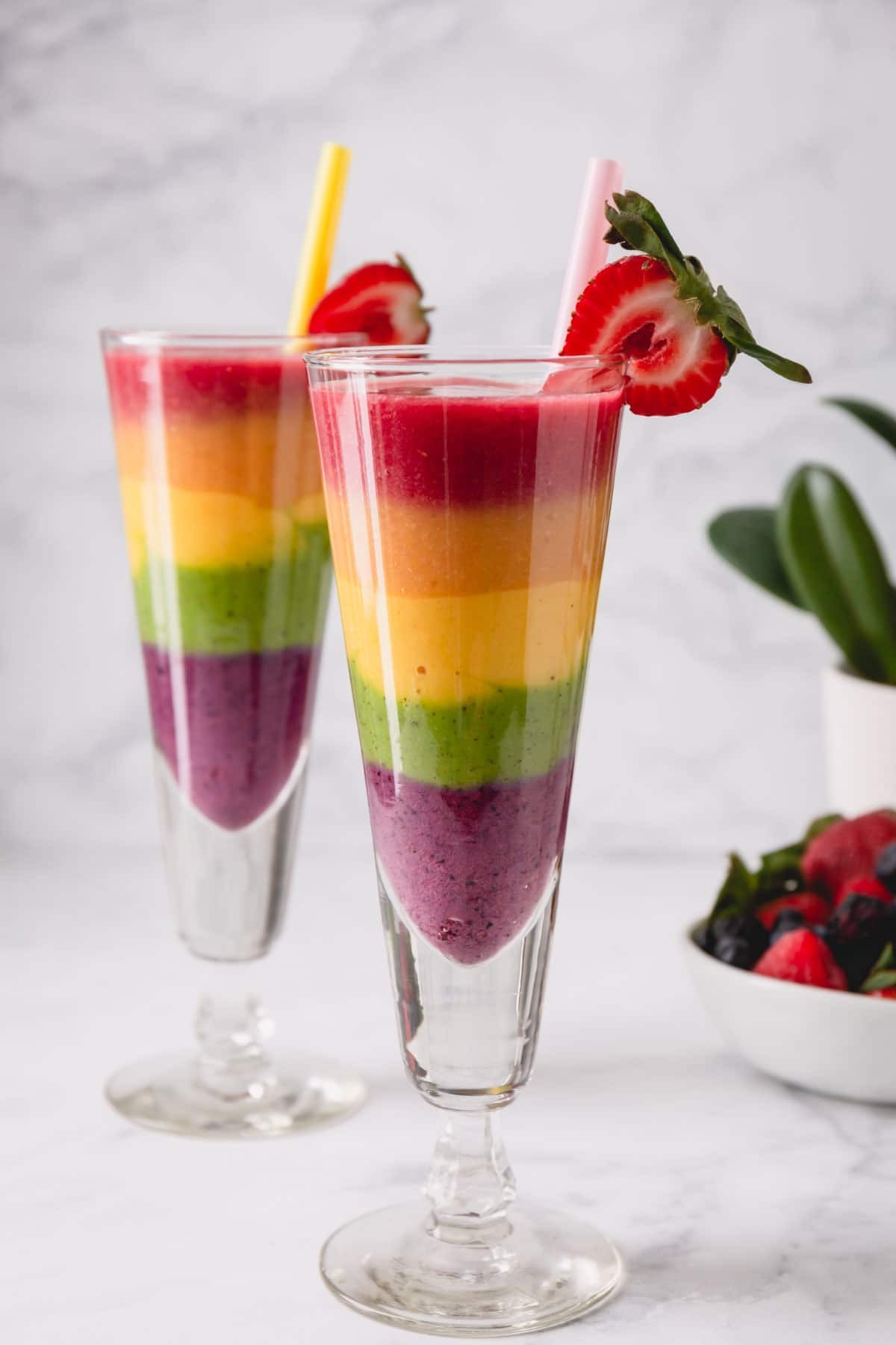 colorful fruit smoothie in a glass with fresh fruits around
