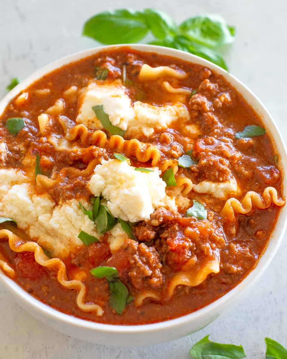 bowl of lasagna soup topped with ricotta cheese
