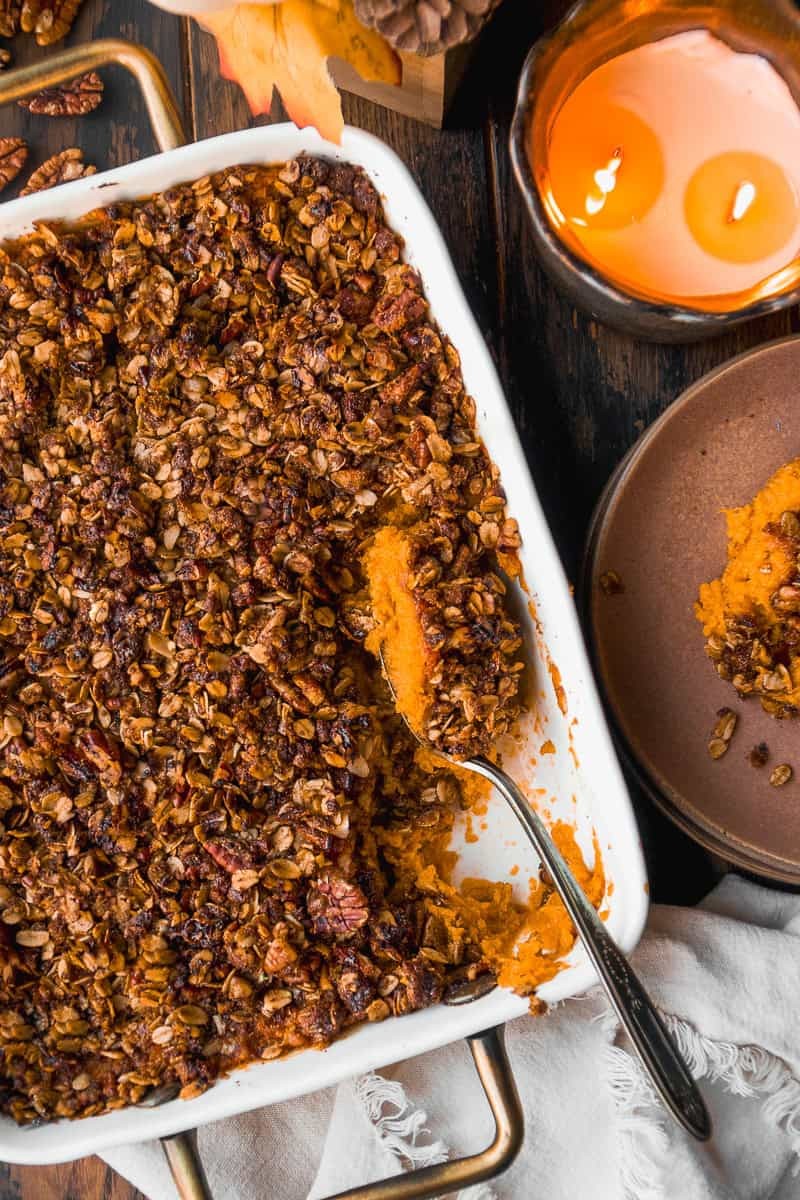 Maple sweet potato casserole with golden nut crunch topping, fall setting, festive table