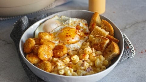delicious tater tot breakfast bowl with a fried egg and cheese, sunny kitchen background