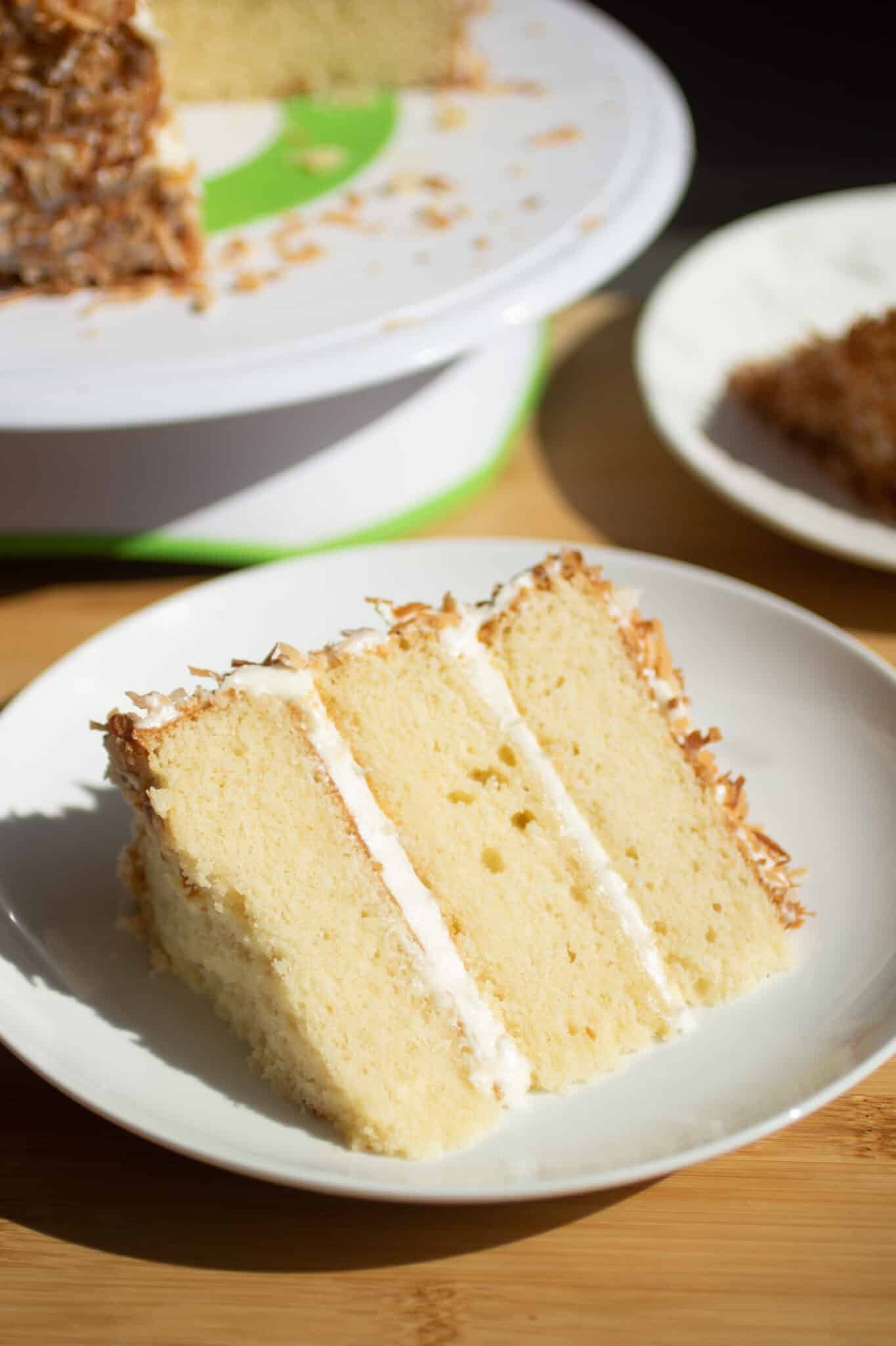 A slice of vanilla birthday cake with coconut cream frosting