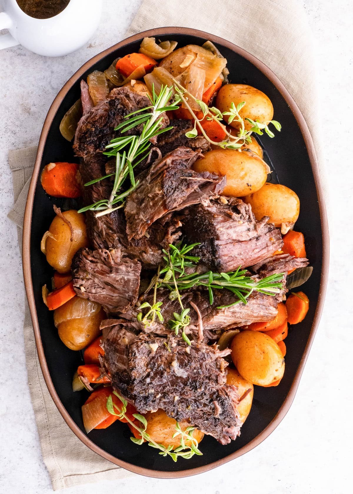 Rustic slow-cooked chili-pepper beef roast with root vegetables, fresh herbs, and a rich gravy