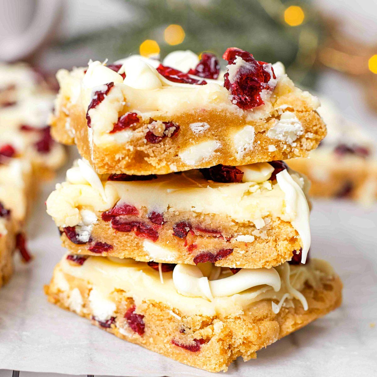 festive cranberry bliss bars with white frosting on a holiday plate, close-up, warm lighting