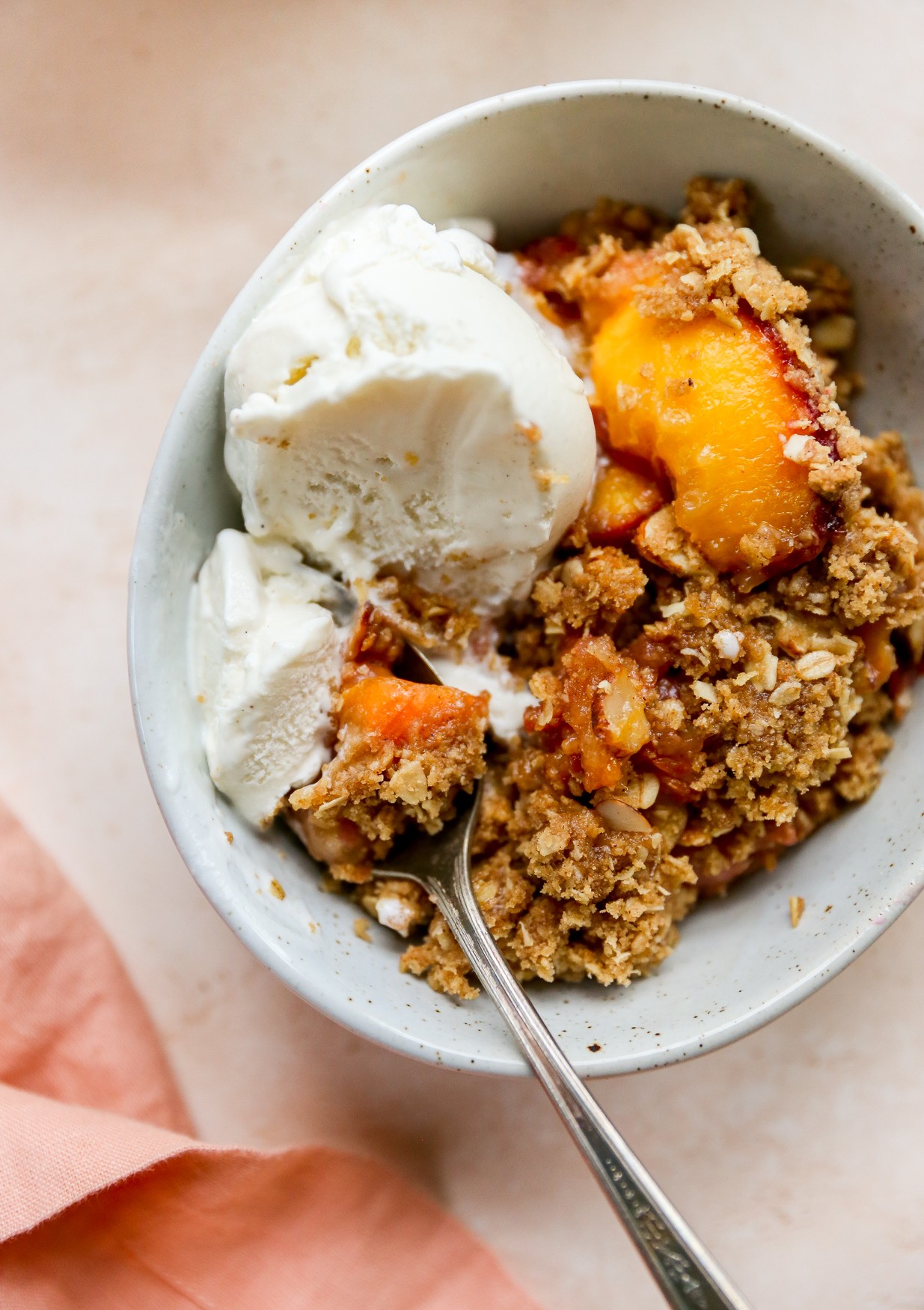 Amaretto Pear Crisp with Almond Slices, golden brown and bubbly, served warm with vanilla ice cream