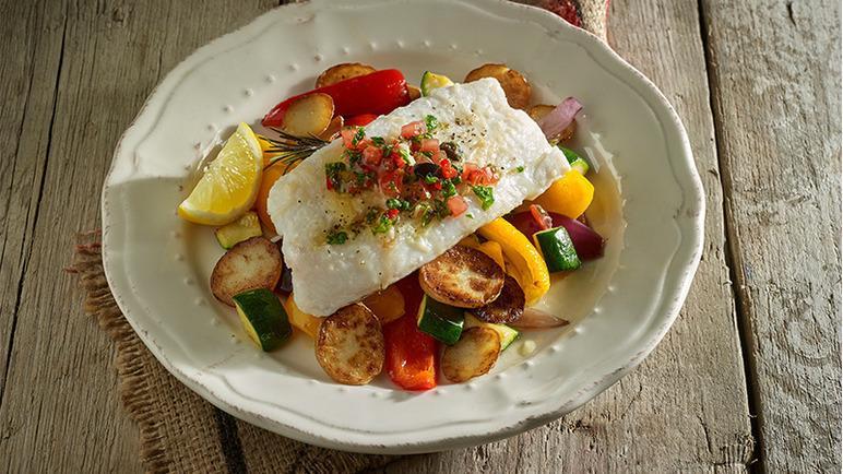 baked cod with colorful roasted vegetables on a plate