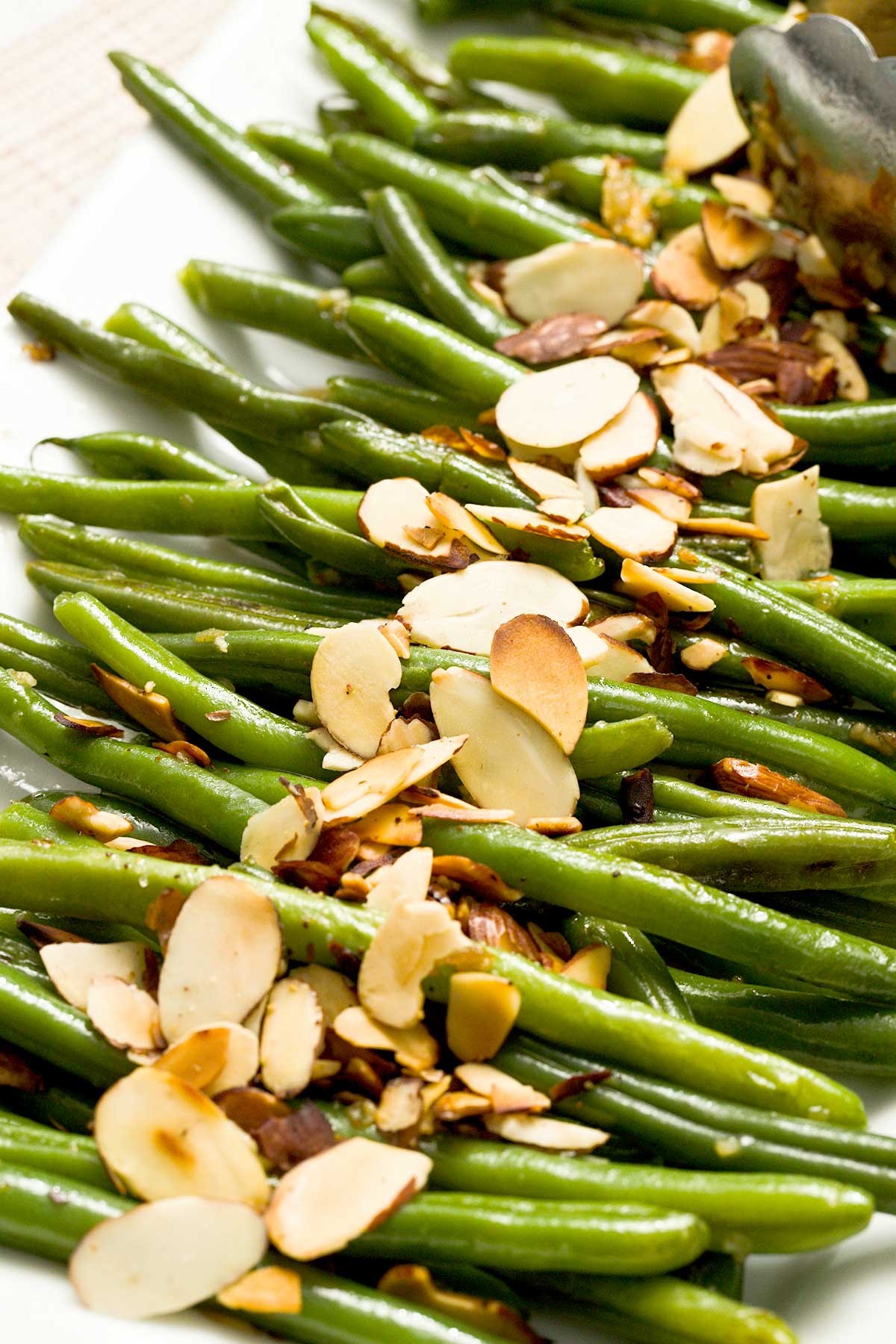 vibrant crispy garlic toasted green beans in a serving dish, close-up, natural light